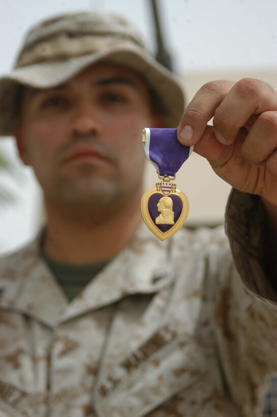 CAMP HURRICANE POINT Ar Ramadi, Iraq (Aug. 9, 2005) - Lance Cpl. Jose O. Martinez, a machine gunner with 4th Platoon, Company W, 1st Battalion, 5th Marine Regiment, narrowly escaped death June 11. The 22-year-old from El Paso, Texas was hit in the face, neck and the back of his head by shrapnel from an improvised explosive device while conducting a night mission with his Marine comrades. For his wounds, Martinez was awarded a Purple Heart during a ceremony here Aug. 2. Martinez is in Iraq a second time with 1st Battalion, 5th Marines in support of Operation Iraqi Freedom. He made it through the fighting in Fallujah unscathed. Photo by: Cpl. Tom Sloan