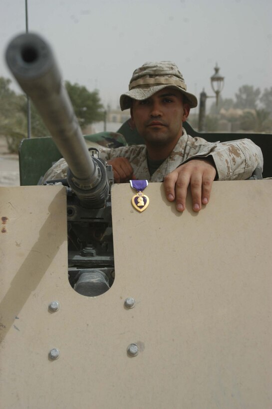 CAMP HURRICANE POINT Ar Ramadi, Iraq (Aug. 9, 2005) - Lance Cpl. Jose O. Martinez, a machine gunner with 4th Platoon, Company W, 1st Battalion, 5th Marine Regiment, narrowly escaped death June 11. The 22-year-old from El Paso, Texas was hit in the face, neck and the back of his head by shrapnel from an improvised explosive device while conducting a night mission with his Marine comrades. For his wounds, Martinez was awarded a Purple Heart during a ceremony here Aug. 2. Martinez is in Iraq a second time with 1st Battalion, 5th Marines in support of Operation Iraqi Freedom. He made it through the fighting in Fallujah unscathed. Photo by: Cpl. Tom Sloan