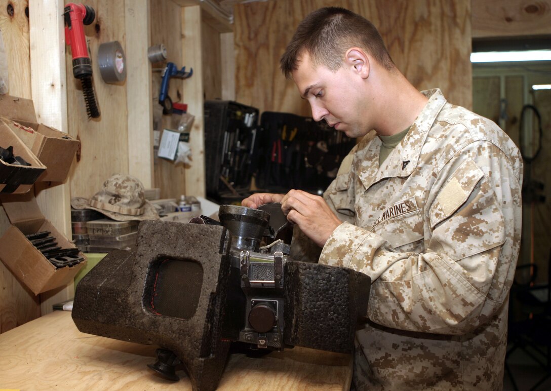 CAMP BAHARIA, Iraq - Lance Cpl. Raphael Brenner, an electro-optical ordnance technician with 1st Battalion, 6th Marine Regiment, performs maintenance on a 98A1 launch unit, a component of the 155mm Howitzer field artillery system.  Every week, the 22-year-old Caledonia, Mich. native and other armory staff troubleshoot, inspect and repair more than 100 rifles, machineguns and night-vision units that infantrymen use while they patrol the streets of Fallujah.