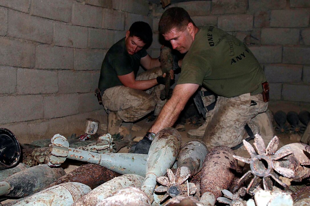 Barwana, Iraq (October 9, 2005)-- Amissville, Va., native Pfc. Michael D. O'Neill and East Point, Ga. native 1st James P. Donovan, combat engineers with 1st CEB attached to 1st LAR move ordnance found in an underground bunker so it can be destroyed.  (Official USMC Photo by Corporal Ken Melton)