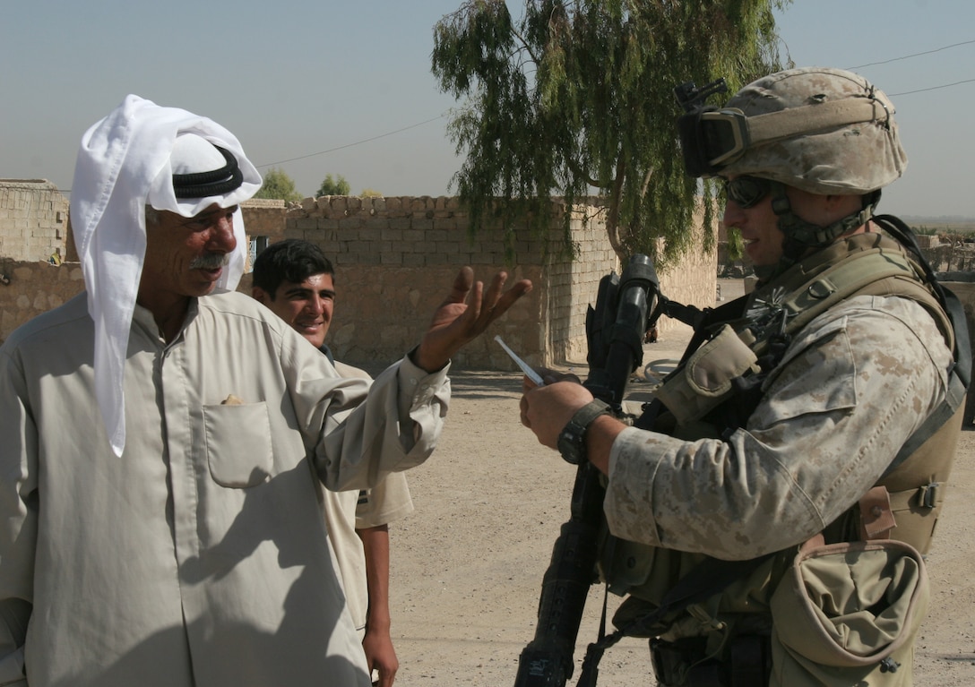 Sgt. Brent Sheets, vehicle commander, Headquarters Platoon, Bravo Company, 2nd Tank Bn., 2nd Marine Division, who was injured in a May 1 IED attack, checks an Iraqi man's identification while operating with Bravo Company Sept. 2. Sheets said the incident made him angry, and he was ready to get back into the fight as soon as he could.