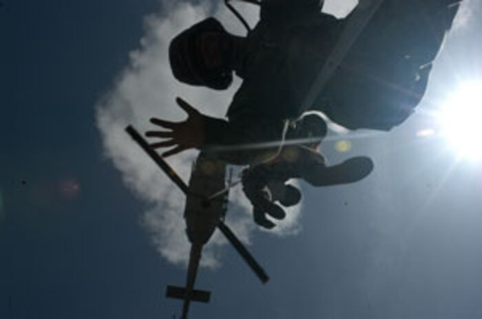 Corporal Khanh Pham, 23, combat engineer, attached from Combat Logistics Battalion 8, 2nd Force Service Support Group (FWD), to 3rd Reconnaissance Battalion, 2nd Marine Division, uses a metal detector to search for possible weapons caches while an Iraqi soldier provides security. Third Reconnaissance Battalion is currently conducting Operation Scimitar in Al Anbar province.