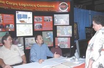 Marine Corps Logistics Command?s joint services branch industrial specialist J.B. King and lead business analyst Ben Martin talk with an attendee during Marine Corps Systems Commands? 11th annual Acquisition Excellence Day at the Hylton Memorial Chapel Event Center in Woodbridge June 1.