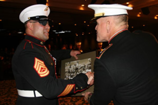 Gunnery Sgt. Nick Popaditch accepts a framed collage of the Combat Center from Maj. Gen. Richard Zilmer after speaking at the MCAGCC Birthday Ball Nov. 9.