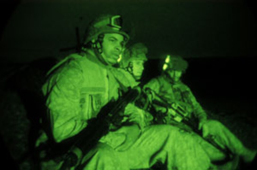 Three Marines with the 15th Marine Expeditionary Unit (Special Operations Capable) sit in a landing zone waiting to assist fellow Marines arriving by helicopter. Most of the 15th MEU's 2,200 Marines and Sailors arrived by helicopter to the Forward Operating Base here. The 15th MEU is currently conducting security and stability operations here in the greater Baghdad area.