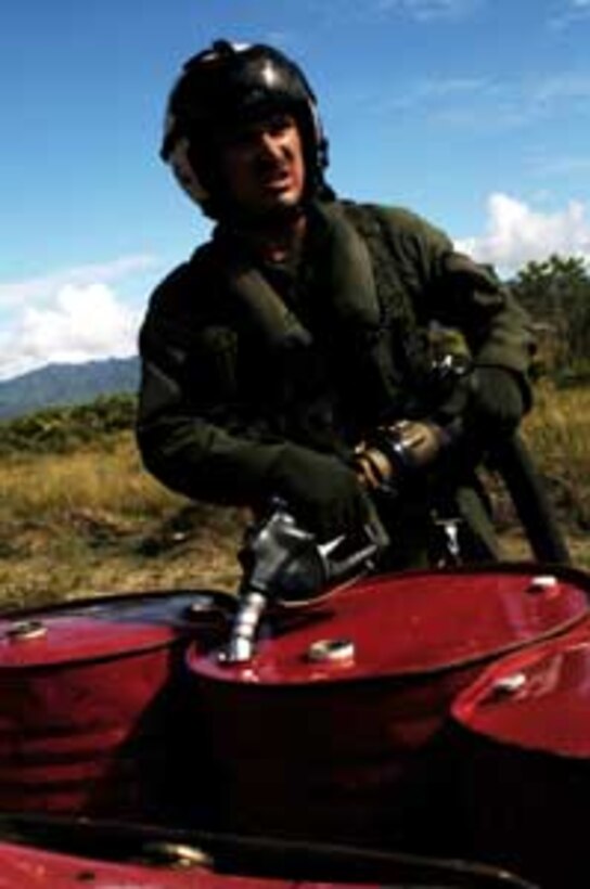 Sgt. Chris Garrison, a CH-53E Super Stallion crew chief, pumps a 55-gallon drum full of JP-8 aviation fuel. The crew pumped more than 1,100 gallons of humanitarian fuel here to help get a fleet of Indonesian helicopters back in the air to support the relief efforts. The 15th Marine Expeditionary Unit (Special Operations Capable) has been providing desperately needed humanitarian aid to cities and villages along more than 150 miles of Sumatra's western coastline.