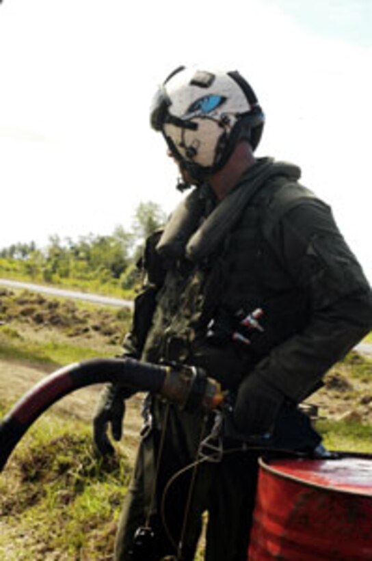 Sgt. Chris Garrison, a CH-53E Super Stallion crew chief, pumps a 55-gallon drum full of JP-8 aviation fuel. The crew pumped more than 1,100 gallons of humanitarian fuel here to help get a fleet of Indonesian helicopters back in the air to support the relief efforts. The 15th Marine Expeditionary Unit (Special Operations Capable) has been providing desperately needed humanitarian aid to cities and villages along more than 150 miles of Sumatra's western coastline.
