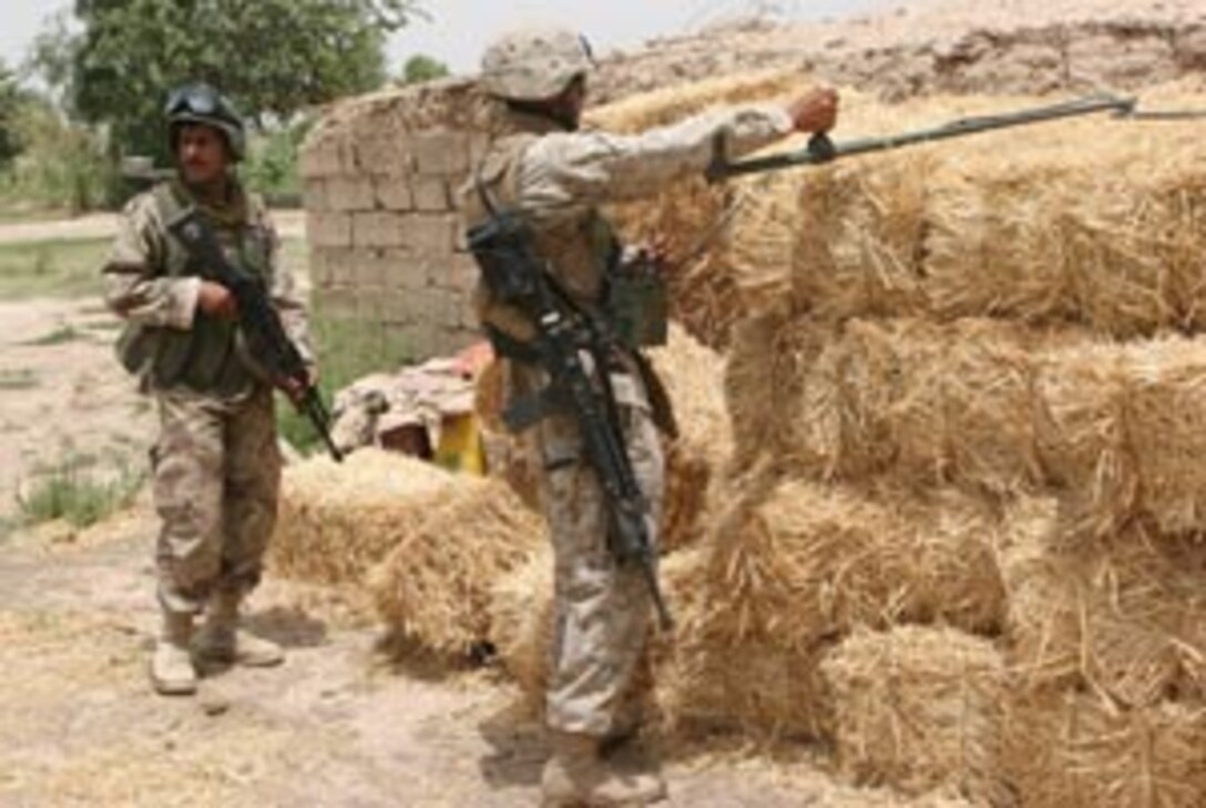 (Center) Sgt. Billy J. Serpas, supply administration clerk, teaches motor transport operators Cpl. Richard McDaniel (left) and Cpl. Cody L. Hopkins, motor transport detachment, MEU Service Support Group 11, 11th Marine Expeditionary Unit, Camp Pendleton, how to assemble the new desert Ultra Lightweight Camouflage Net System during the building of an Initial Support Base, also known as a Forward Operating Base by the Marines of the, during a Humanitarian Assistance Operation training exercise at Red Beach here Nov. 9. The desert ULCANS replaces the Desert Lightweight Camouflage Screen System in use since the 1970s. The new cammie netting is easier to assemble and disassemble and doesn?t snag on as many things as the old one did, said McDaniels. Marines and sailors from MSSG-11 security, communications, medical, motor transport, utilities and other support detachments set up the FOB to serve as the central distribution and re-supply point of food, water, medical and other materials for the HAO site.