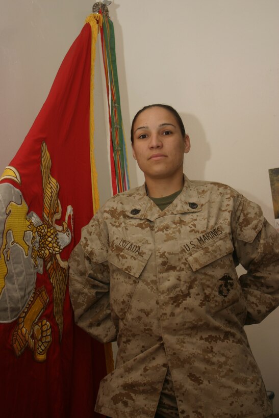 AL ASAD, Iraq- Staff Sgt. Mayra Lazada stands in front of the Marine Tactical Air Control Squadron 28 colors. Nicaraguan born Lazada decided to join the Marine Corps to show her appreciation for the United States granting her family political asylum in 1984 from civil war torn Nicaragua