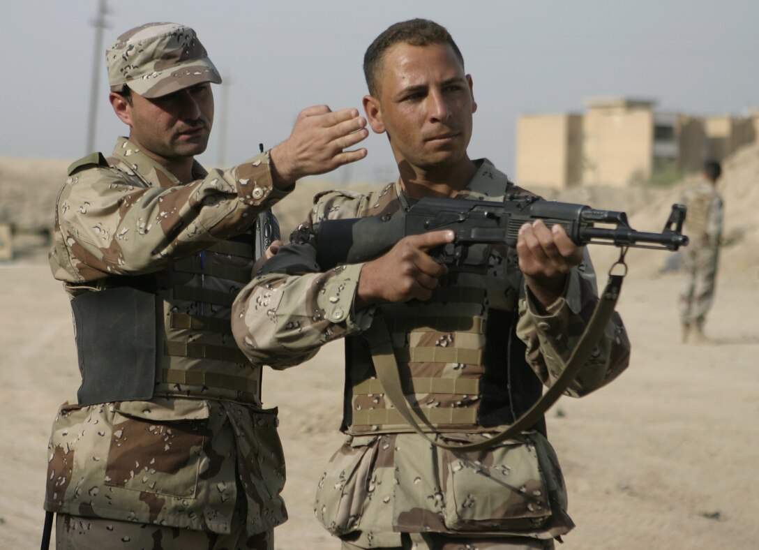 FALLUJAH, Iraq - An Iraqi soldier shows his recruit proper aiming technique during a training evolution here.  Iraqi Security Forces personnel are working side-by-side with 1st Battalion, 6th Marine Regiment to conduct a "Lion Training" program to teach new Iraqi army recruits fundamentals of marksmanship, first aid in combat, and military customs and courtesies.