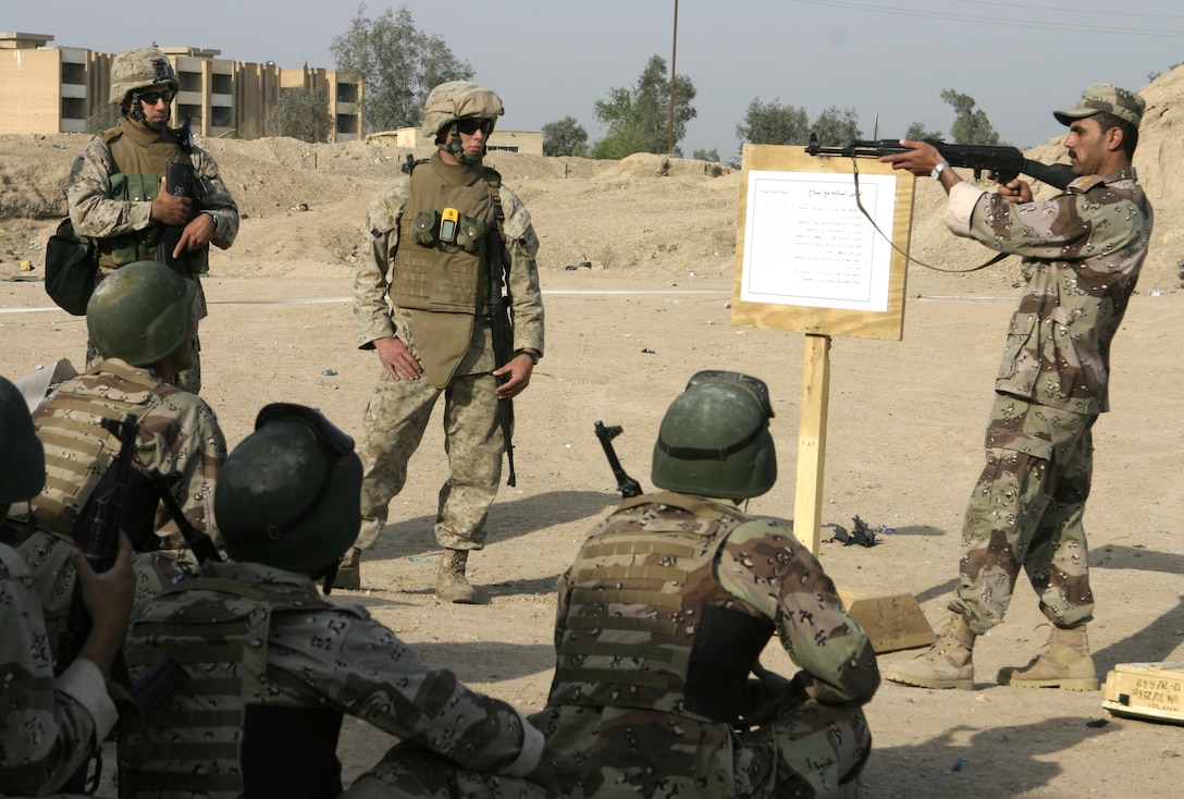 FALLUJAH, Iraq - An Iraqi officer stands in front of his recruits and demonstrates proper aiming techniques during a training evolution here.  Iraqi Security Forces personnel are working side-by-side with 1st Battalion, 6th Marine Regiment to conduct a "Lion Training" program to teach new Iraqi army recruits fundamentals of marksmanship, first aid in combat, and military customs and courtesies.