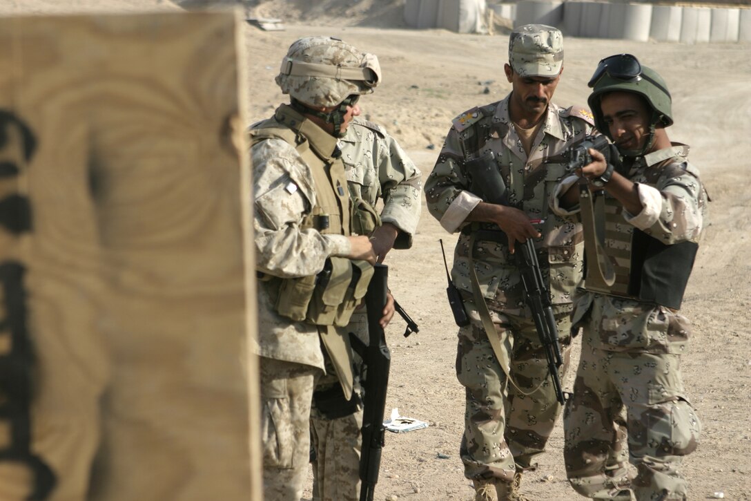 FALLUJAH, Iraq - An Iraqi first lieutenant, or Mulaazem Awwal, and a Marine from 1st Battalion, 6th Marine Regiment observe an Iraqi recruit as he takes aim at a target and prepares to fire.  Iraqi Security Forces personnel are working side-by-side with 1st Battalion, 6th Marine Regiment to conduct a "Lion Training" program to teach new Iraqi army recruits fundamentals of marksmanship, first aid in combat, and military customs and courtesies.