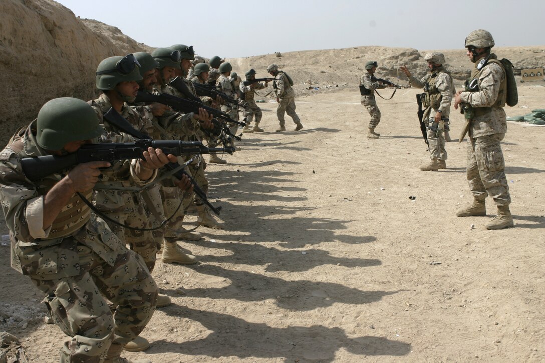 FALLUJAH, Iraq - Iraqi recruits practice taking aim near the firing line as Marines from 1st Battalion, 6th Marine Regiment and Iraqi instructors observe.  Iraqi Security Forces personnel are working side-by-side with 1st Battalion, 6th Marine Regiment to conduct a "Lion Training" program to teach new Iraqi army recruits fundamentals of marksmanship, first aid in combat, and military customs and courtesies.