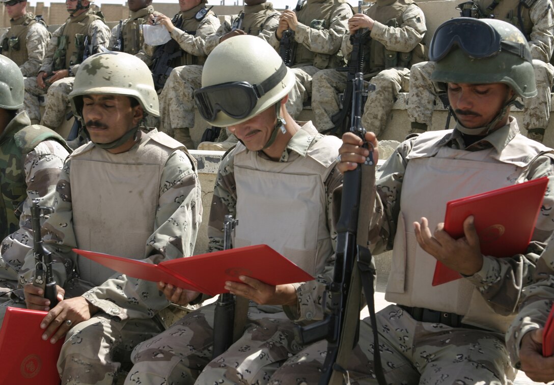 FALLUJAH, Iraq - Soldiers with the Iraqi Security Forces' 2nd Brigade look at their graduation certificates after their graduation ceremony here.  The soldiers graduated April 30 from a five-day long squad tactics training course, during which 1st Battalion, 6th Marine Regiment personnel taught them skills such as patrolling, first aid in combat and urban war fighting tactics.