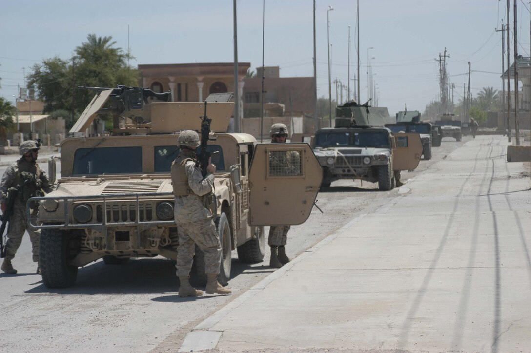 AR RAMADI, IRAQ (May 10, 2005) - Marines with Mobile 1, Company C, 1st Battalion, 5th Marine Regiment, secure a street here for Marines with Team 1, Detachment 3, 5th Civil Affairs Group. The civil affairs Marines conducted a detailed battle site assessment of two automotive shops that elements of 1st Battalion, 5th Marine Regiment, damaged during a recent cordon and search mission. Marines with 5th CAG will ensure the owners are properly compensated for the damages incurred to their establishments. Photo by Cpl. Tom Sloan