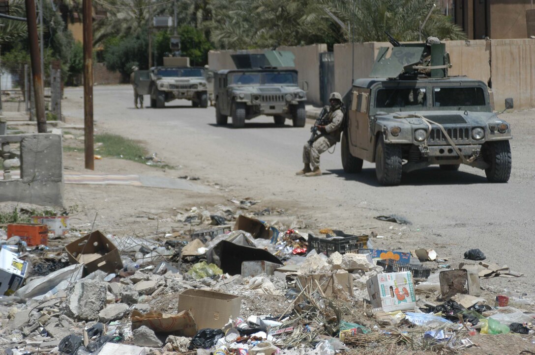 AR RAMADI, IRAQ (May 10, 2005) - Sergeant Hector Martinez Jr., noncommissioned officer with Team 1, Detachment 3, 5th Civil Affairs Group, leans against an up-armored Humvee and uses it for cover during a mission in the city here. The 28-year-old from Fontana, Calif., and his fellow civil affairs Marines conducted a detailed battle site assessment of two automotive shops that elements of 1st Battalion, 5th Marine Regiment, damaged during a recent cordon and search mission. Marines with 5th CAG will ensure the owners are properly compensated for the damages incurred to their establishments. They also assessed other areas in the city they believe need improving. Photo by Cpl. Tom Sloan