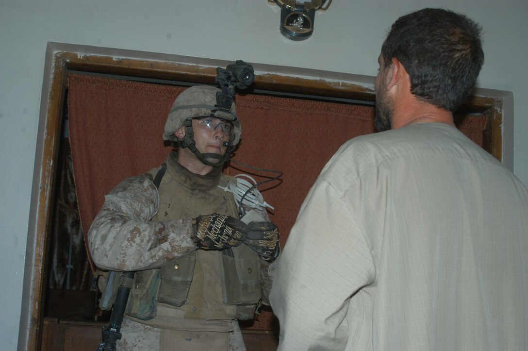 AR RAMADI Iraq (July 10, 2005) - Corporal Michael T. Wheat, a mortar man with 4th Platoon, Company W, 1st Battalion, 5th Marine Regiment, checks an Iraqi man's identification card during a mission in the city here early July 10. The 21-year-old from Merkel, Texas, and fellow Marines with 3rd and 4th Platoon conducted a raid between 1 a.m. and 3 a.m., during which time they captured an insurgent responsible for launching small arms and improvised explosive device(IED) attacks on coalition forces. Photo by: Cpl. Tom Sloan