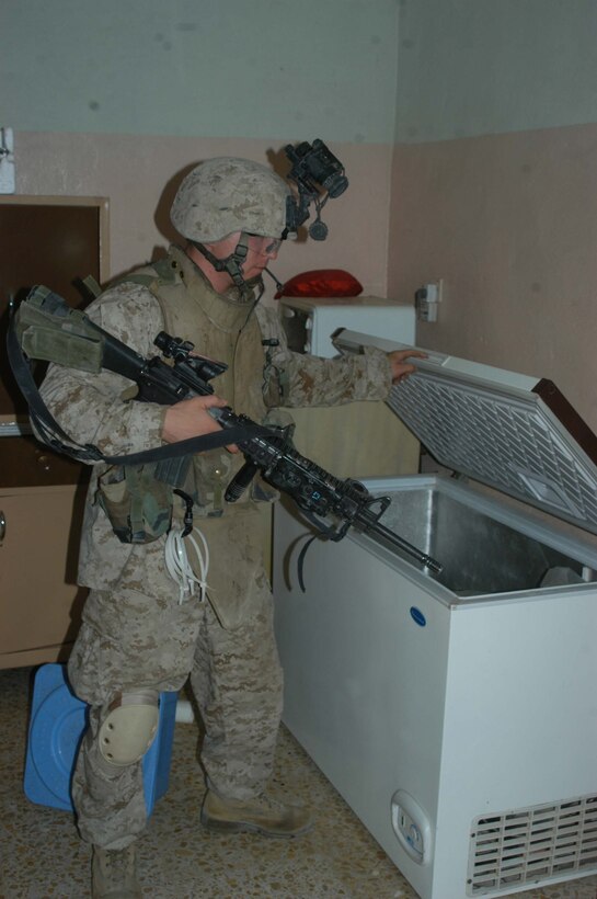 AR RAMADI Iraq (July 10, 2005) - Corporal Paul M. Titus, a mortar man with 4th Platoon, Company W, 1st Battalion, 5th Marine Regiment, searches a house for threats during a mission in the city here early July 10. The 22-year-old from Yonkers, N.Y., and fellow Marines with 3rd and 4th Platoon conducted a raid between 1 a.m. and 3 a.m., during which time they captured an insurgent responsible for launching small arms and improvised explosive device(IED) attacks on coalition forces. Photo by: Cpl. Tom Sloan