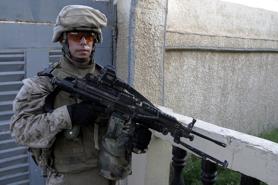 FALLUJAH, Iraq - Lance Cpl. Benjamin Pellum, a squad automatic weapon gunner with 4th Platoon, Company B, 1st Battalion, 6th Marine Regiment, provides security at the entrance of a residency here July 10 during Operation Rolling Barrage.  The 23-year-old Chesterfield, Va. native worked alongside fellow infantrymen, mechanized units and Iraqi Security Forces to block off and search neighborhoods throughout the city for weapons, explosives and insurgent activity.