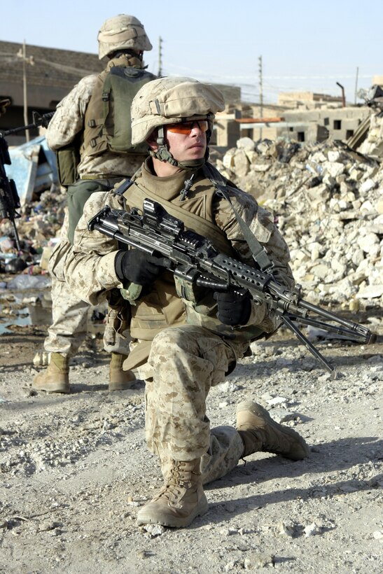 FALLUJAH, Iraq - Lance Cpl. Benjamin Pellum, a squad automatic weapon gunner with 4th Platoon, Company B, 1st Battalion, 6th Marine Regiment, provides security along a street here July 10 during Operation Rolling Barrage.  The 23-year-old Chesterfield, Va. native worked alongside fellow infantrymen, mechanized units and Iraqi Security Forces to block off and search neighborhoods throughout the city for weapons, explosives and insurgent activity.