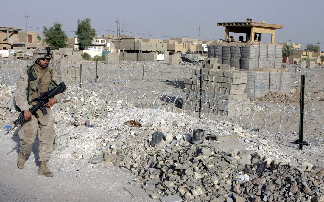 FALLUJAH, Iraq - An infantryman with 4th Platoon, Company B, 1st Battalion, 6th Marine Regiment patrols through a street here July 10 during Operation Rolling Barrage.  Company B personnel worked alongside fellow infantrymen, mechanized units and Iraqi Security Forces to block off and search neighborhoods throughout the city for weapons, explosives and insurgent activity.