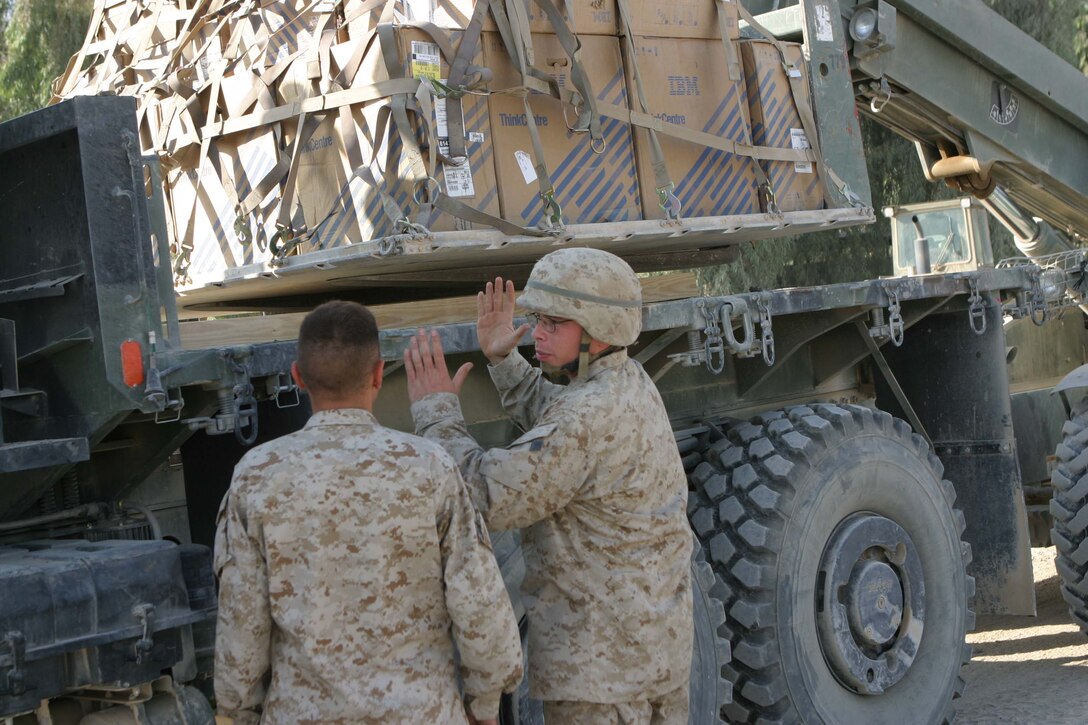 CAMP BLUE DIAMOND, RAMADI, Iraq - Lance Corporal Jesse D. Glennon, a heavy equipment operator, with Combat Service Support Detachment 28 attached to the Camp Lejeune, N.C. based 2nd Marine Division talks to a fellow Marine here before loading supplies on to a truck to be convoyed to another camp. Glennon is in the Marine Corps Reserves in Jacksonville, Fl and volunteered to be deployed in support of Operation Iraqi Freedom. Glennon spends the majority of his time loading and offloading the much needed supplies that keep the 2nd Marine Division operational. Official U.S. Marine Corps photo by Sgt. Ryan S. Scranton