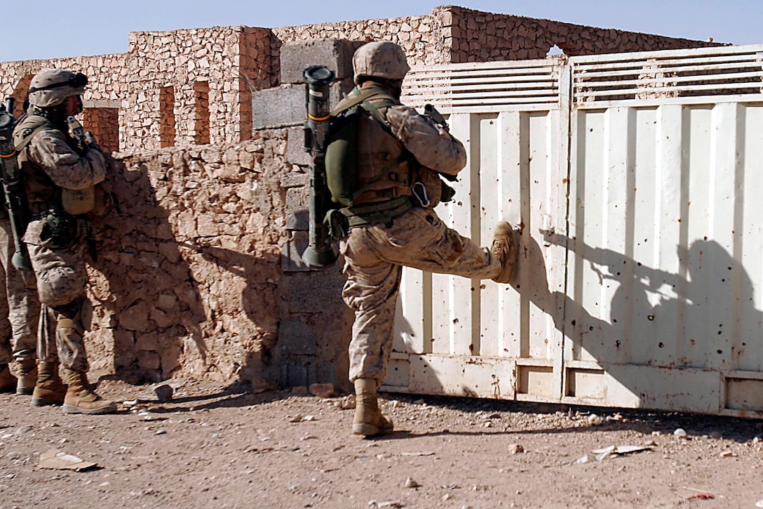 Husaybah, Iraq ( November 10, 2005)-- A scout with 2nd platoon, 1st LAR breaches a door while on patrol during Operation Steel Curtain on the Marine Corps' 230th Birthday. The Marines found a cache and were given a hot meal at the end of day in celebration of the holiday. (Official U. S. Marine Corps photo by Corporal Ken Melton)