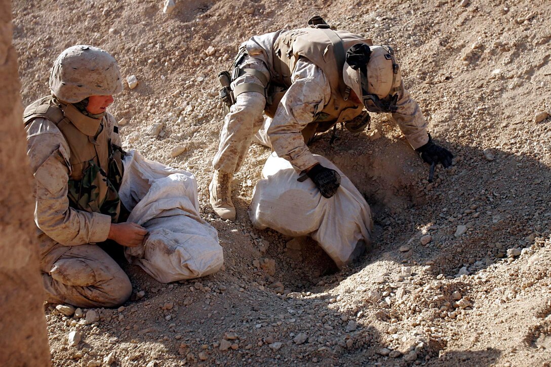 Husaybah, Iraq ( November 10, 2005)-- A combat engineers with 2nd platoon, 1st LAR pull out bags of mines while on patrol during Operation Steel Curtain on the Marine Corps' 230th Birthday. The cache find was plus since it was the Marine Corps Birthday. They were also given a hot meal at the end of day in celebration of the holiday. (Official U. S. Marine Corps photo by Corporal Ken Melton)
