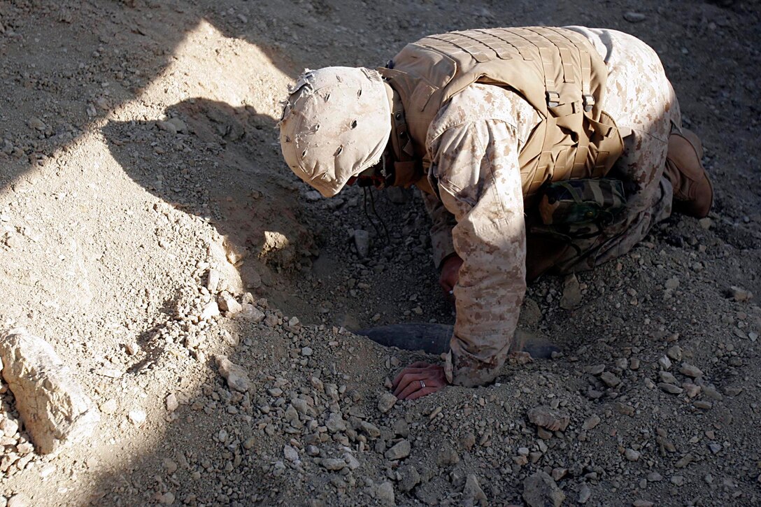 Husaybah, Iraq ( November 10, 2005)-- A combat engineer with 2nd platoon, 1st LAR uncovers artillery shells while on patrol during Operation Steel Curtain on the Marine Corps' 230th Birthday. The cache find was a plus since it was the Marine Corps birthday. They were also given a hot meal at the end of day in celebration of the holiday. (Official U. S. Marine Corps photo by Corporal Ken Melton)