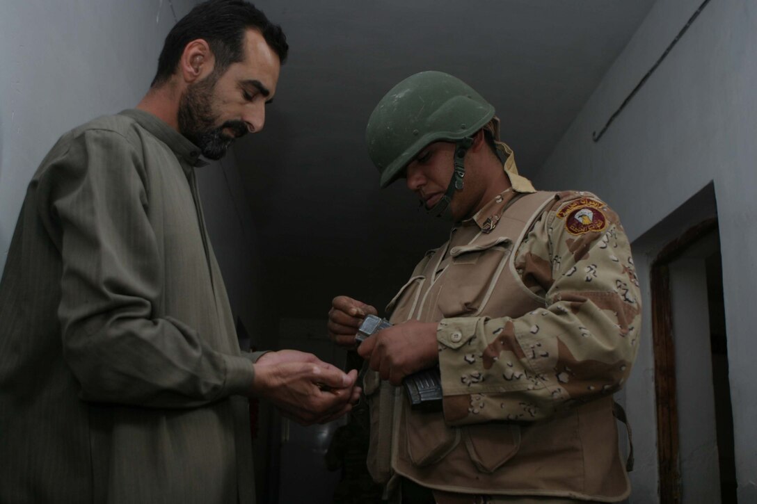 CAMP DEFENDER, RAMADI, Iraq - An Iraqi soldier with 1st Battalion, 1st Brigade of the 7th Iraqi Army Division removes the ammunition from the magazine of an AK-47 during Operation Lions here. Operation Lions was a major milestone for 1-1-7 who operated independent from U.S. military support. Official U.S. Marine Corps photo by Sgt. Ryan S. Scranton