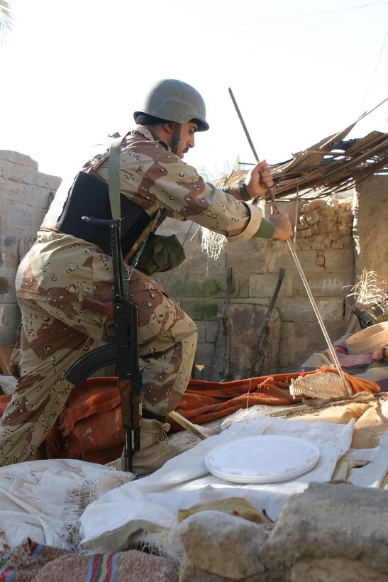 CAMP DEFENDER, RAMADI, Iraq -  An Iraqi soldier with 1st Battalion, 1st Brigade of the 7th Iraqi Army Division searches through bags of flour with and Iron rod looking for hidden weapons during Operation Lions. Operation Lions was a major milestone for 1-1-7 who operated independent from U.S. military support. Official U.S. Marine Corps photo by Sgt. Ryan S. Scranton