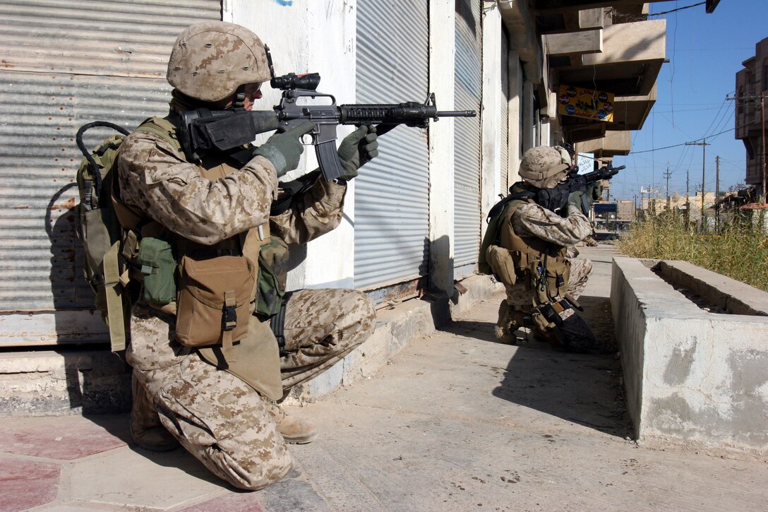 AR RAMADI, Iraq (December 10, 2005) - Two Marines with Company K, 3rd Battalion, 7th Marine Regiment search an area for insurgents during a patrol Dec. 10. Photo by Cpl. Shane Suzuki