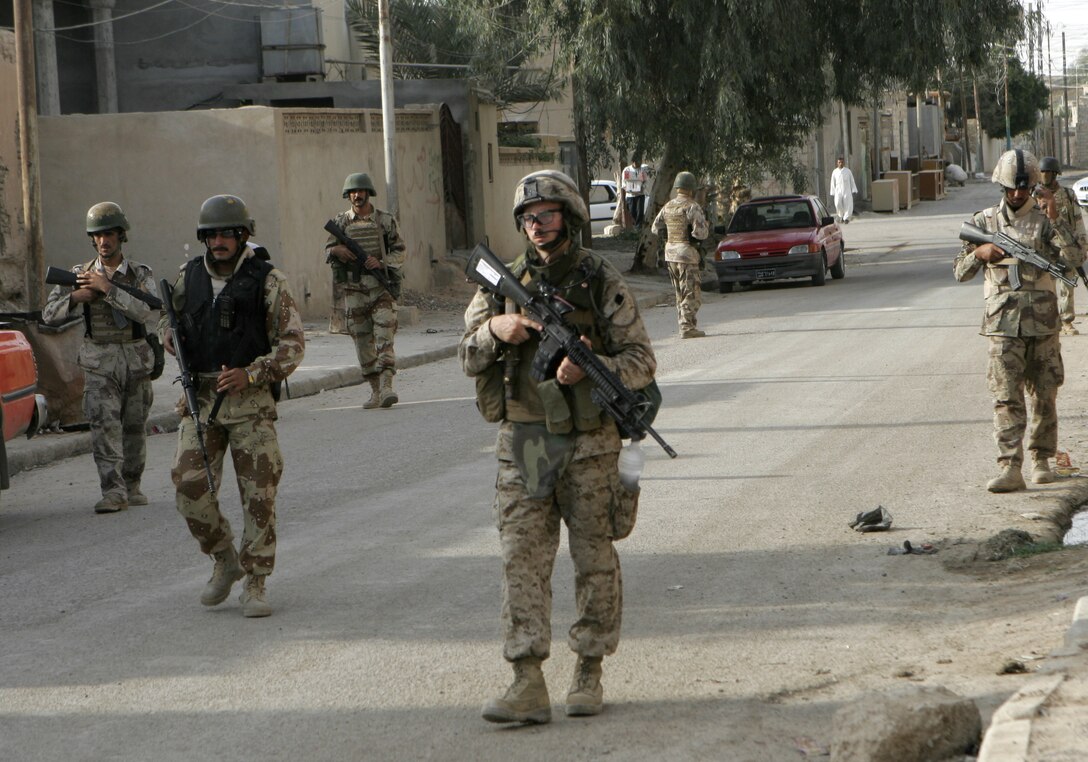FALLUJAH, Iraq - A Marine infantryman from Echo Company, 2nd Battalion, 6th Marine Regiment, 2nd Marine Division, and Iraqi soldiers assigned with 4th Company, 2nd Battalion, 2nd Brigade, Iraq Intervention Force, conduct a foot patrol here recently. Backed by the infantrymen and with the experience of Marine advisors from Military Transition Team 7, II Marine Expeditionary Force (FWD), Iraqi troops continue making progress in assuming a greater security role for this city and their country. (Official U.S. Marine Corps photo by Cpl. Ruben D. Maestre)