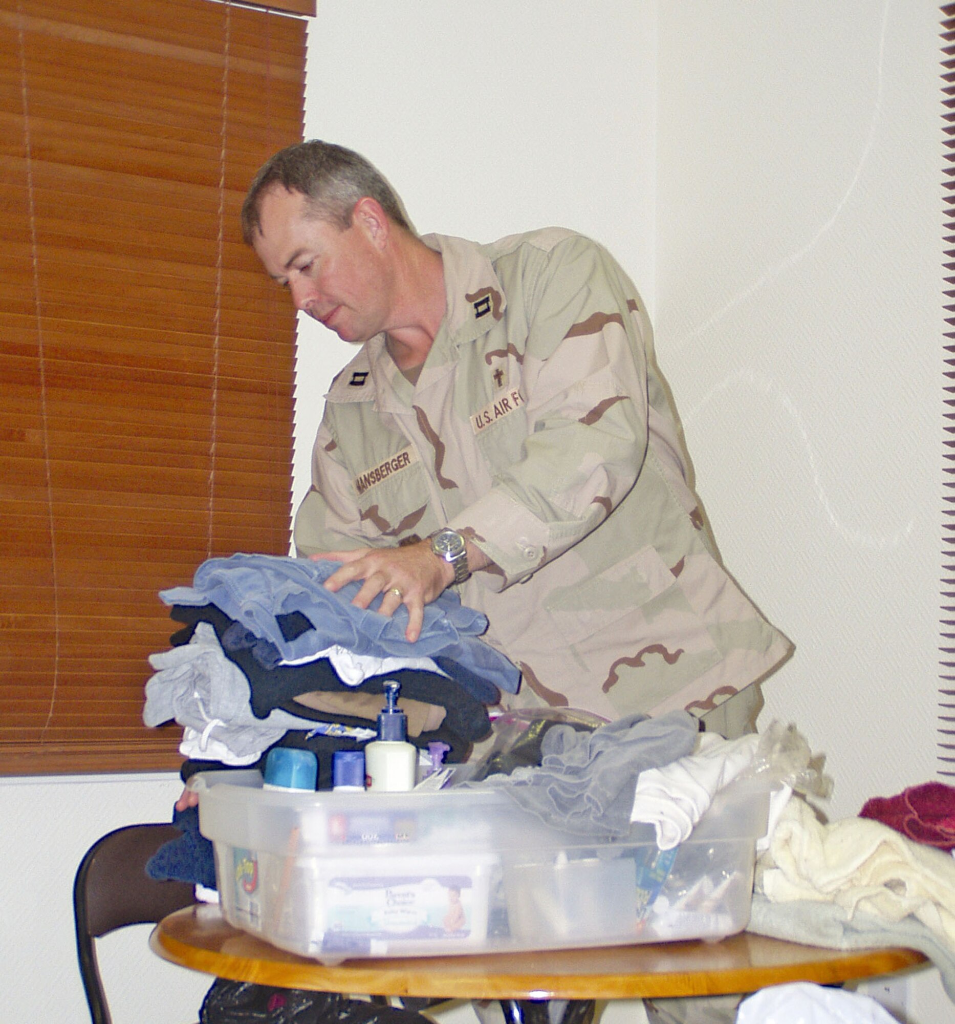 SOUTHWEST ASIA -- Chaplain (Capt.) David Mansberger organizes clothes and toiletry items donated by people at a forward-deployed location here.  Chapel officials are working with local churches to donate items to those in need.  (Courtesy photo)  