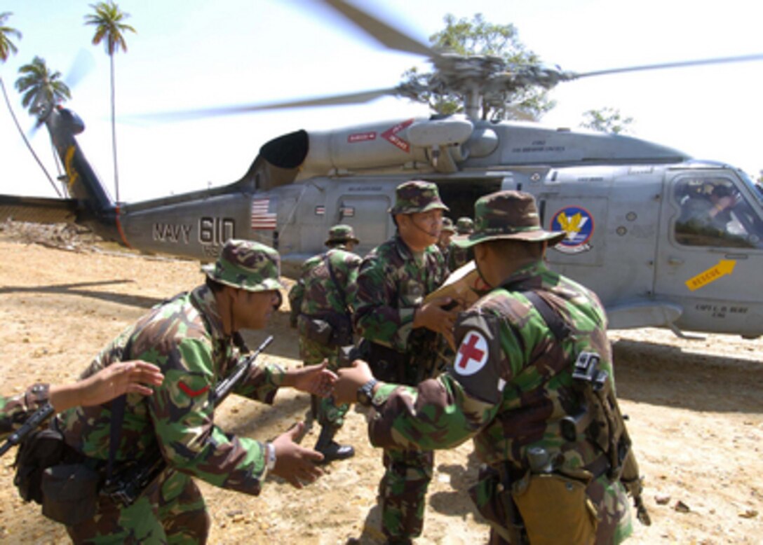 Indonesian soldiers unload relief supplies from a U.S. Navy SH-60 Seahawk helicopter in the village of Tjalang, Sumatra, Indonesia, on Jan. 2, 2005. The SH-60 is assigned to Helicopter Anti-Submarine Squadron 2 deployed aboard USS Abraham Lincoln (CVN 72). The aircraft carrier USS Abraham Lincoln (CVN 72) and its embarked Carrier Air Wing Two 2 are operating in the Indian Ocean off the coasts of Indonesia and Thailand in support of Operation Unified Assistance. 