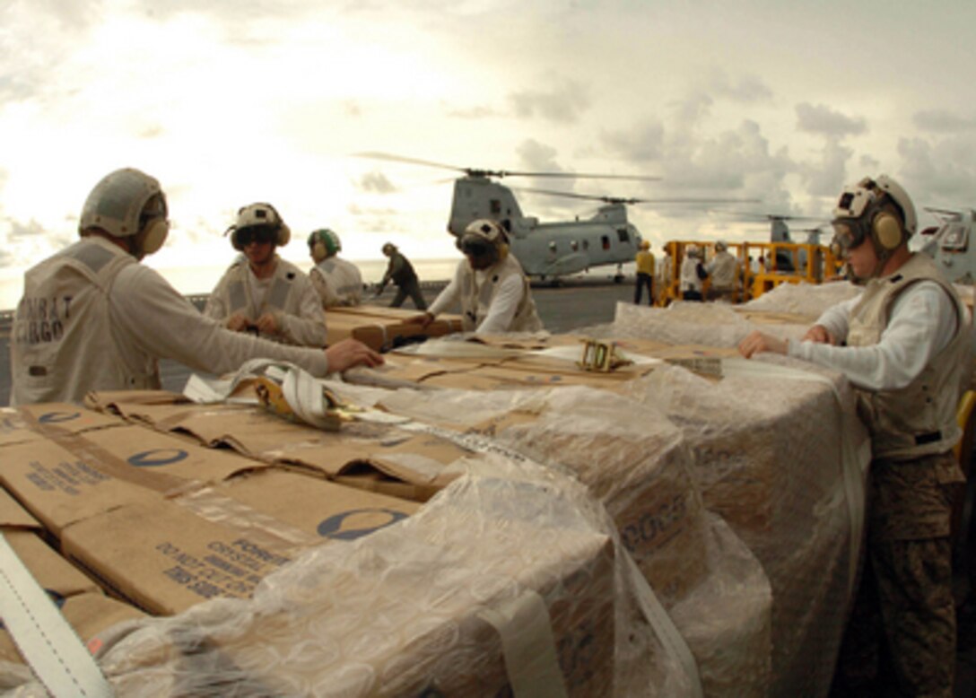 U.S. Marines assigned to the Combat Cargo Division aboard USS Bonhomme Richard (LHD 6) prepare pallets of packaged Meals Ready-to-Eat for delivery to tsunami-stricken areas of Indonesia on Jan. 6, 2005. Helicopters from Richard and sailors and Marines assigned to Expeditionary Strike Group 5 are providing humanitarian assistance to areas devastated by the Dec. 26, 2004, Indian Ocean tsunami as part of Operation Unified Assistance. 