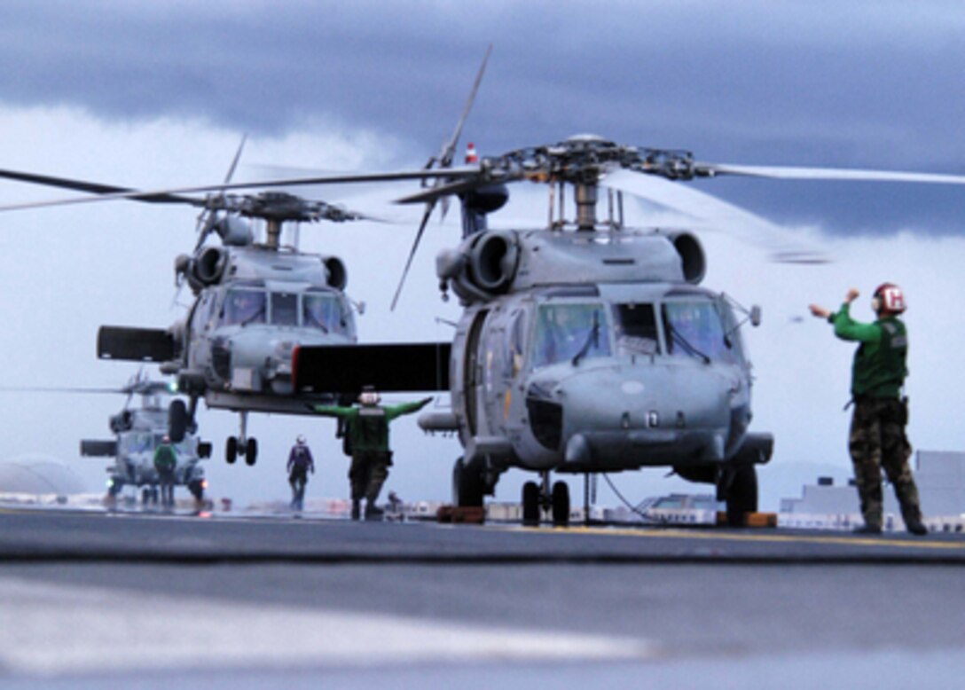 Carrier Air Wing 2 helicopters land on USS Abraham Lincoln (CVN 72) after a full day of delivering food and supplies to tsunami-stricken victims in Sumatra, Indonesia, on Jan. 7, 2005. The Lincoln Carrier Strike Group is currently operating in the Indian Ocean off the coasts of Indonesia and Thailand as part of Operation Unified Assistance. 