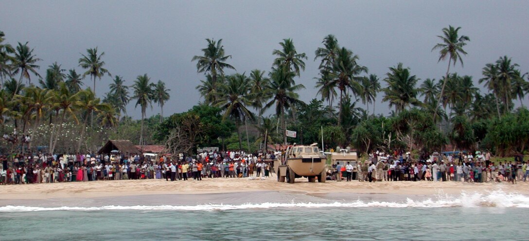 Local residents stand on the beach to watch Marines and Sailors as they head back to USS Duluth. The 15th Marine Expeditionary Unit (Special Operations Capable) provides desperately needed humanitarian aid to cities and villages along Sri Lanka's southern coastline.