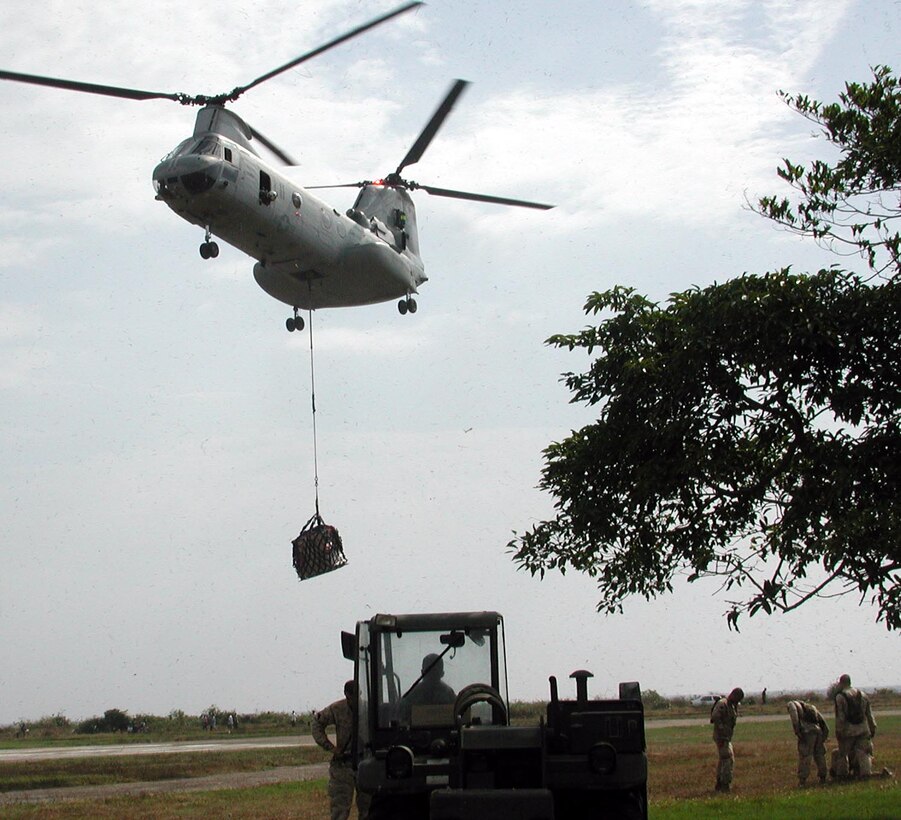 A CH 46 with the 15th Marine Expeditionary Unit (Special Operations Capable) carries humanitarian aid supplies from the USS Duluth to an air field here while Marines of the same unit  standby to distribute the supplies.  The 15th Marine Expeditionary Unit (Special Operations Capable) provided desperately needed humanitarian aid to cities and villages along Sri Lanka's southern coastline.