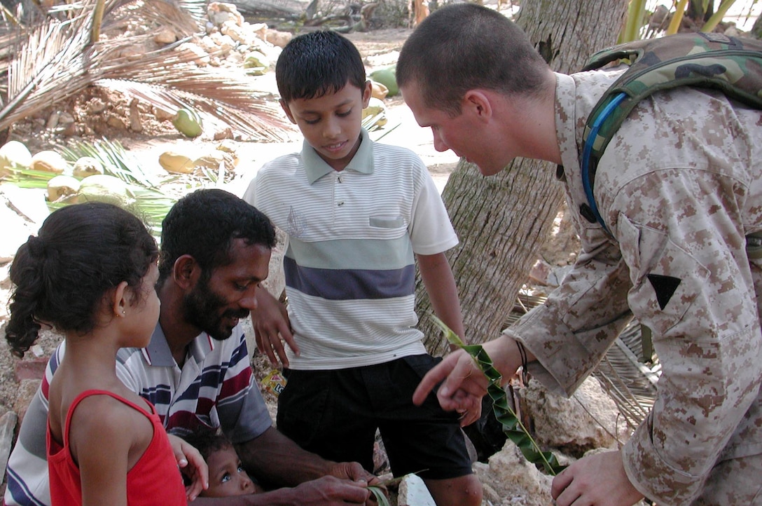 Shortly after arriving on the beach here, HN Daniel Keenan, a corpsman with MEU Service Support Group 15,  speaks with a Sri Lankan family about medical issues. The 15th Marine Expeditionary Unit (Special Operations Capable) has been providing desperately needed humanitarian aid to cities and villages along the coast of Sri Lanka's southern coastline.