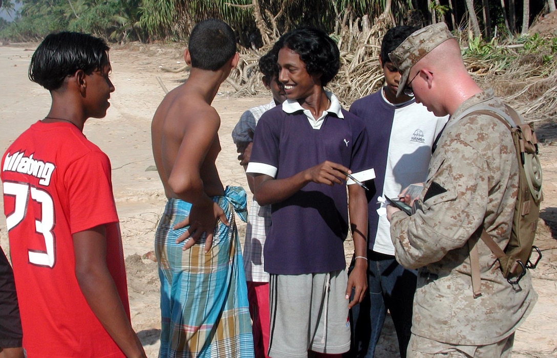 Lance Cpl. Matthew Flemming of MEU Service Support Group 15 exchanges mailing addresses w/ local teenagers. The 15th Marine Expeditionary Unit (Special Operations Capable) provided desperately needed humanitarian aid to cities and villages along Sri Lanka's southern coastline.