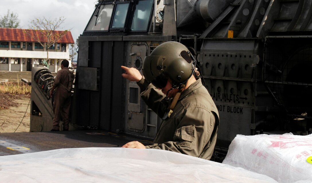 MEULABOH, Indonesia (Jan. 10, 2005) -- BM1 Patrcik Padilla, 38, a loadmaster with Beach Master Unit 1 and native of Las Cruces, N.M., direct a forklift operator as they unload humanitarian aid. The 15th Marine Expeditionary Unit (Special Operations Capable) and Amphibious Squadron 7 have been providing desperately needed humanitarian aid to cities and villages along more than 150 miles of Sumatra's western coastline.  (Photo by Gunnery Sgt. Robert Knoll)