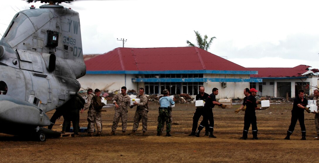 MEULABOH, Indonesia (Jan. 10, 2005) -- A team of Marines, aid workers and locals unload aid from a CH-46E Sea Knight helicopter at an airfield here. The 15th Marine Expeditionary Unit (Special Operations Capable) has been providing desperately needed humanitarian aid to cities and villages along more than 150 miles of Sumatra's western coastline.  (Photo by Gunnery Sgt. Robert Knoll)