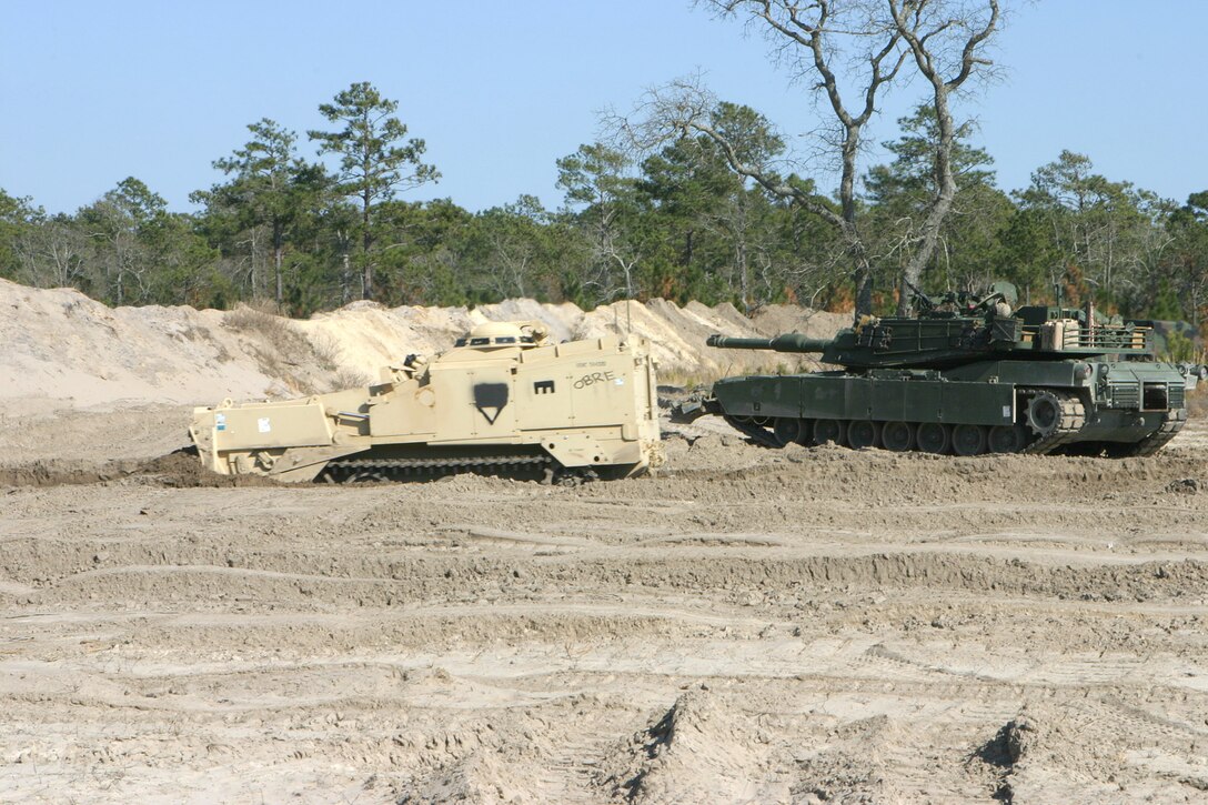 MAIRNE CORPS BASE CAMP LEJEUNE, N.C. (March 10, 2005) ? The Armored Combat Excavator heads through the tank trench in front of the berm while an M1A1 Abrams tank and its crew keep watch for enemies during a breaching operation at Engineer Training Area 2 March 10.  The exercise lasted three days and included numerous training evolutions.