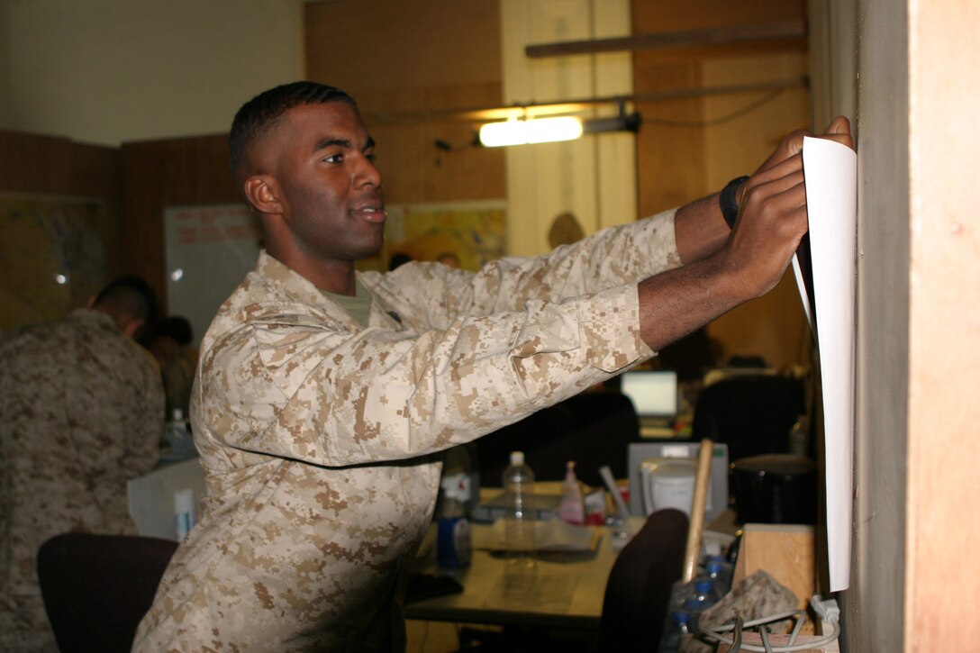 Sergeant Cryst Banks, a 21-year-old personnel administration clerk, Washington D.C. native and 2d Marine Division Morale Welfare and Recreation liaison posts a flyer to advertise Colin Quinn, a veteran comic and former comedy writer for Saturday Night Live who is touring some of the camps in the area this month.  It's Banks' job to arrange for entertainment on the camps to boost morale.  U.S. Marine Corps photo by Sgt. Stephen D'Alessio (RELEASED)