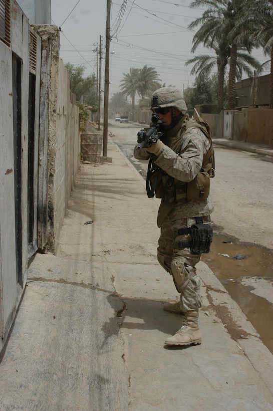 AR RAMADI Iraq (June 11, 2005) - With M-16A4 at the ready, Lance Cpl. James M. Adkins, an assault man with 1st Section, 5th Mobile Assault Platoon, Company W, 1st Battalion, 5th Marine Regiment, checks an open gate along a street here for threats during a mission in the city. The 26-year-old from Knoxville, Tenn., and his fellow warriors conducted a presence patrol in the southern part of the city in an effort to uncover insurgent activity and deter them from operating. The platoon was engaged by an enemy sniper and hit an improvised explosive device during the operation. No one was hurt and no vehicles were damaged. Photo by: Cpl. Tom Sloan.