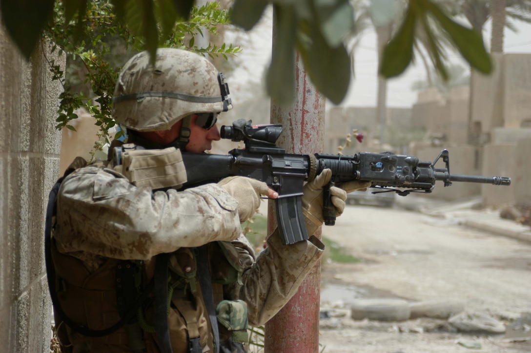 AR RAMADI Iraq (June 11, 2005) - With M-16A4 at the ready, Lance Cpl. James M. Adkins, an assault man with 1st Section, 5th Mobile Assault Platoon, Company W, 1st Battalion, 5th Marine Regiment, posts security from a street corner here for his fellow Marines during a mission in the city. The 26-year-old from Knoxville, Tenn., and his fellow warriors conducted a presence patrol in the southern part of the city in an effort to uncover insurgent activity and deter them from operating. The platoon was engaged by an enemy sniper and hit an improvised explosive device during the operation. No one was hurt and no vehicles were damaged. Photo by: Cpl. Tom Sloan.