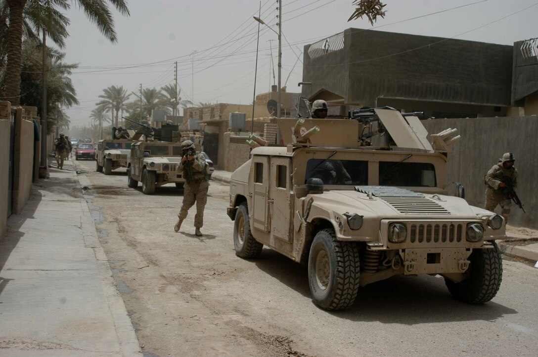 AR RAMADI Iraq (June 11, 2005) - Marines with 5th Mobile Assault Platoon, Company W, 1st Battalion, 5th Marine Regiment, quickly move through a neighborhood in the city here during a mission. The platoon conducted a presence patrol in the southern part of the city in an effort to uncover insurgent activity and deter them from operating. The platoon was engaged by an enemy sniper and hit an improvised explosive device during the operation. No one was hurt and no vehicles were damaged. Photo by: Cpl. Tom Sloan.