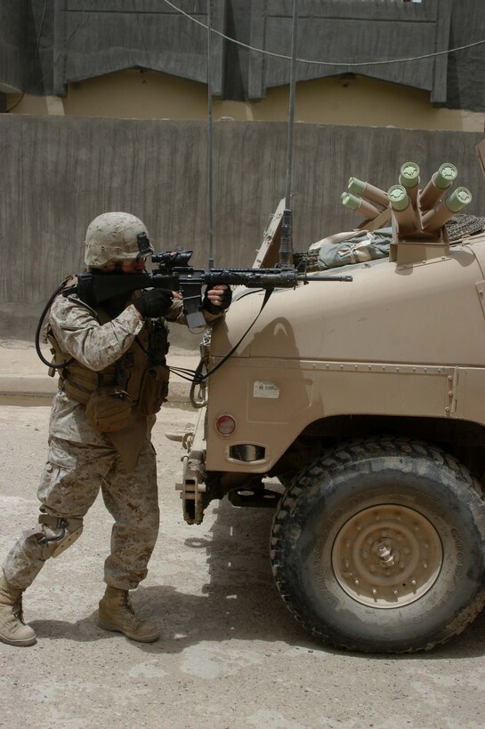 AR RAMADI Iraq (June 11, 2005) - First Lieutenant Adam W. Burch, the platoon commander for 5th Mobile Assault Platoon, Company W, 1st Battalion, 5th Marine Regiment, uses a Humvee for security during a mission in the city here. The 28-year-old from Saratoga, N.Y., and his fellow warriors conducted a presence patrol in the southern part of the city in an effort to uncover insurgent activity and deter them from operating. The platoon was engaged by an enemy sniper and hit an improvised explosive device during the operation. No one was hurt and no vehicles were damaged. Photo by: Cpl. Tom Sloan.