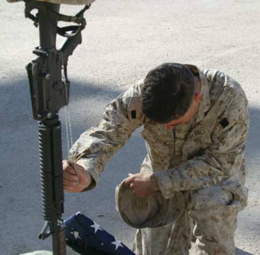 A Marine from Company E, 2nd Battalion, 6th Marines pays his respects to Cpl. Joshua D. Snyder during a memorial service Dec. 11.  Snyder, a 20-year-old Hampstead, Md. Native, was killed in action Nov. 30, 2005 by anti-coalition forces while deployed with Company E, 2nd Battalion, 6th Marines.
